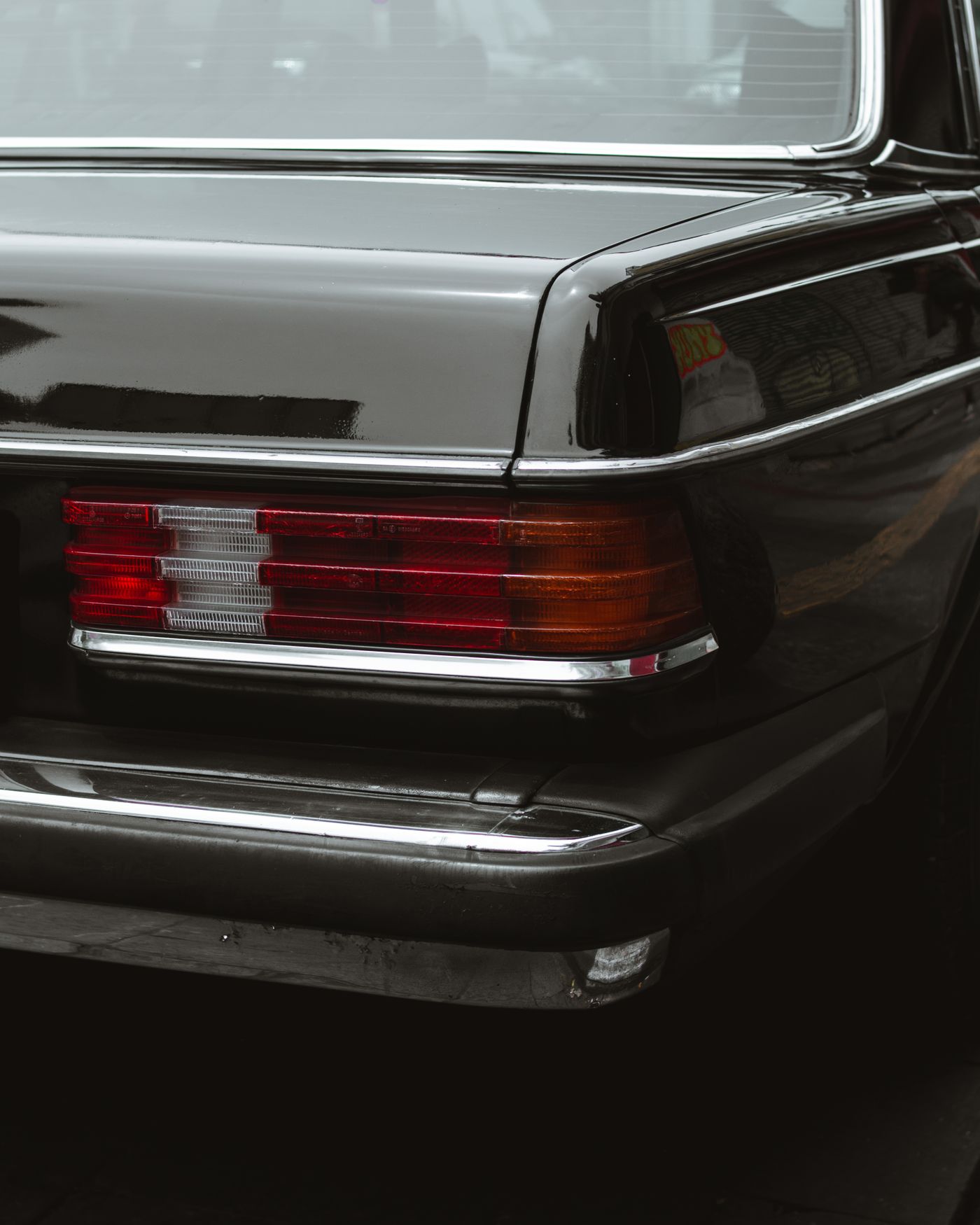 Close-up of a black Mercedes rear light and chrome detailing